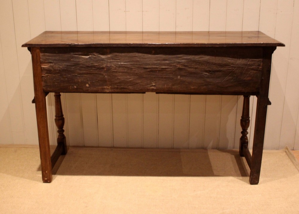 A Jacobean style carved oak dresser base with two geometric moulded drawers, split spindle mouldings, and turned front legs. View XII