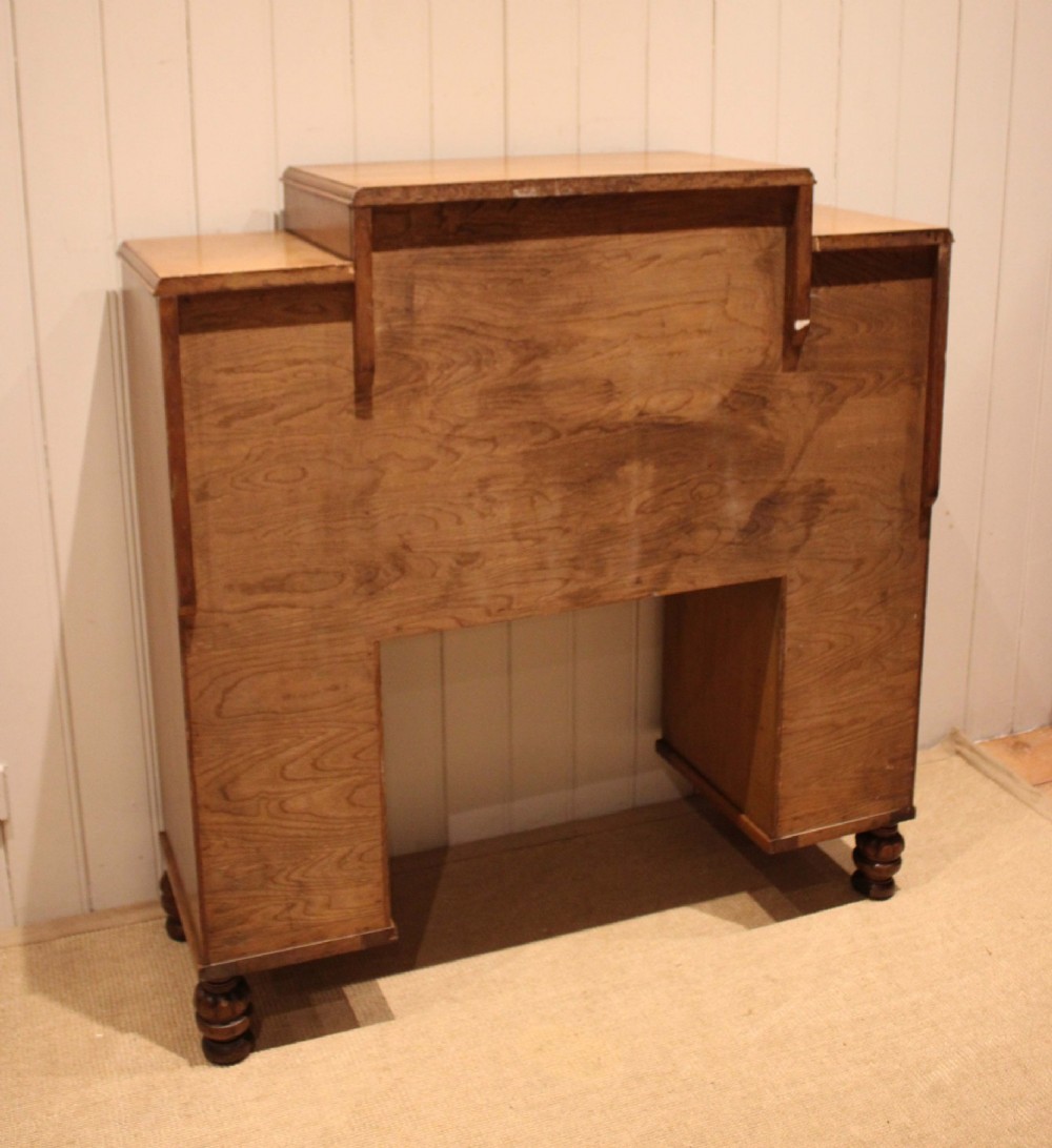 An antique oak bureau cabinet featuring a central fall-front writing compartment above a single drawer, flanked by two side cupboards with panelled doors and raised on turned feet. View XII