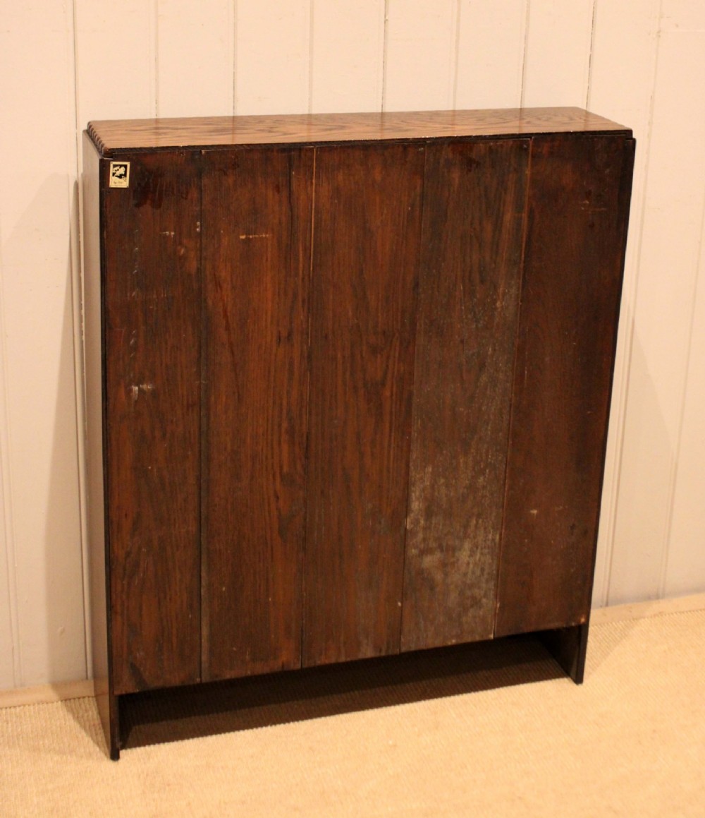 A low dark oak open bookcase with three shelving tiers, a beaded top edge, and fluted bracket feet. View XIV