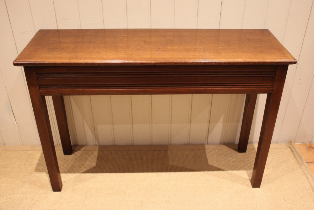 A late 19th-century oak hall table with a rectangular top, grooved apron detail, and four straight legs.