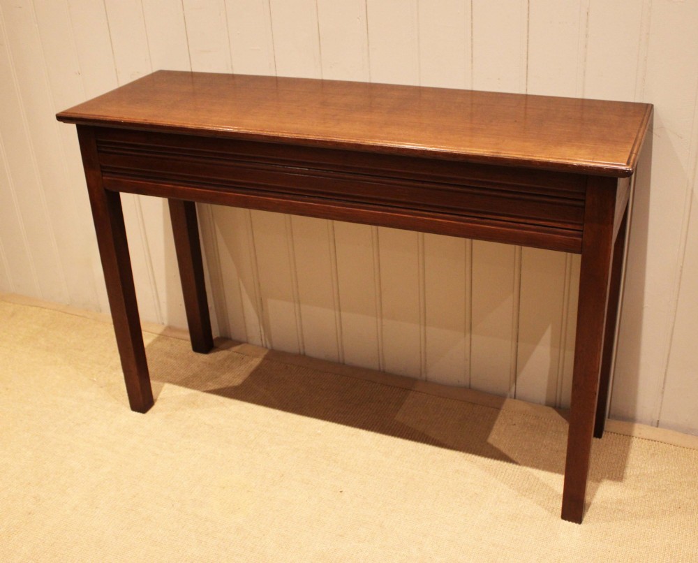 A late 19th-century oak hall table with a rectangular top, grooved apron detail, and four straight legs. View II