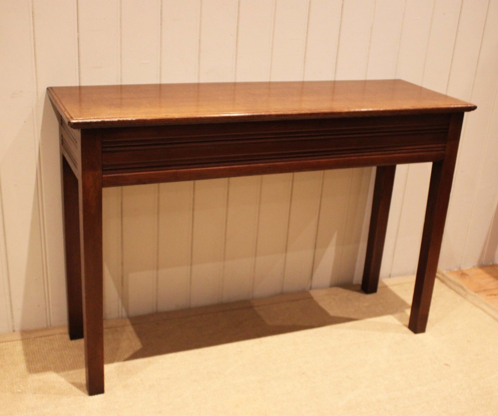 A late 19th-century oak hall table with a rectangular top, grooved apron detail, and four straight legs. View VI