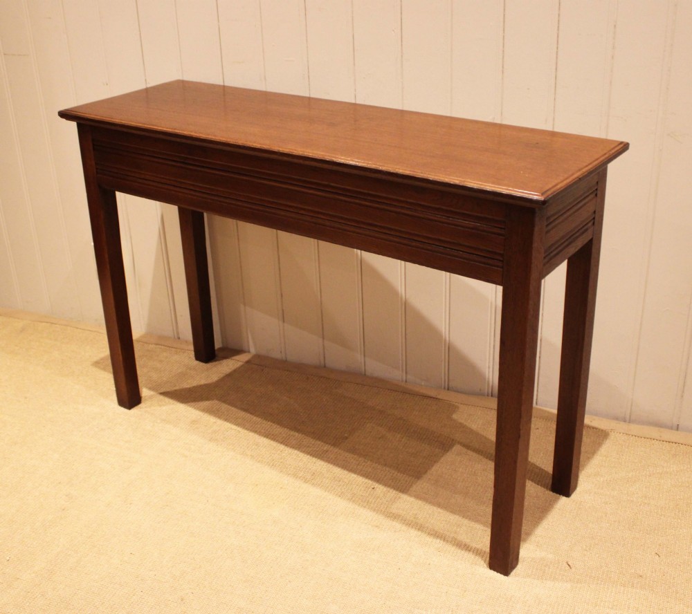 A late 19th-century oak hall table with a rectangular top, grooved apron detail, and four straight legs. View IX