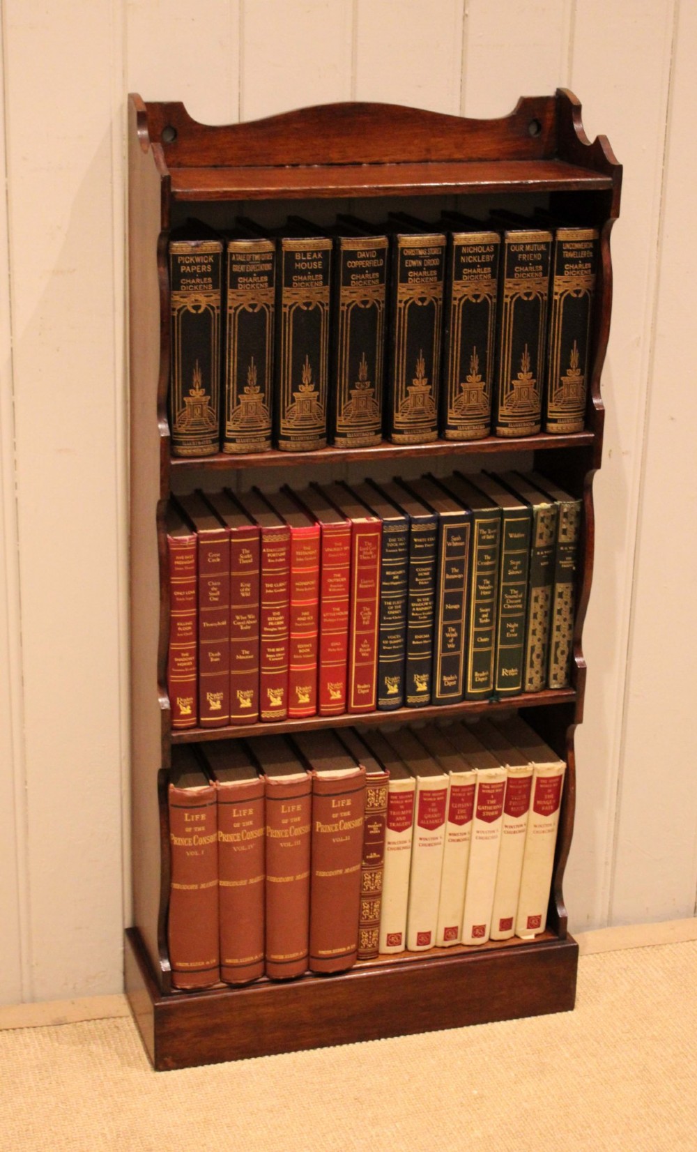 A small dark oak open bookcase featuring four tier shelves, shaped side panels, and a scrolled top gallery. View II
