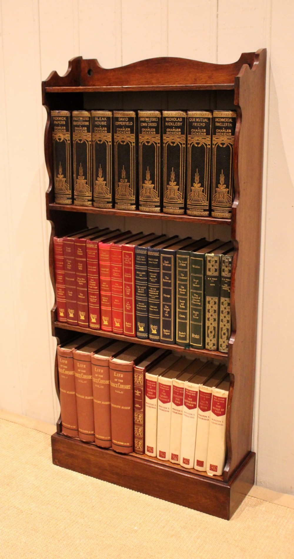 A small dark oak open bookcase featuring four tier shelves, shaped side panels, and a scrolled top gallery. View V
