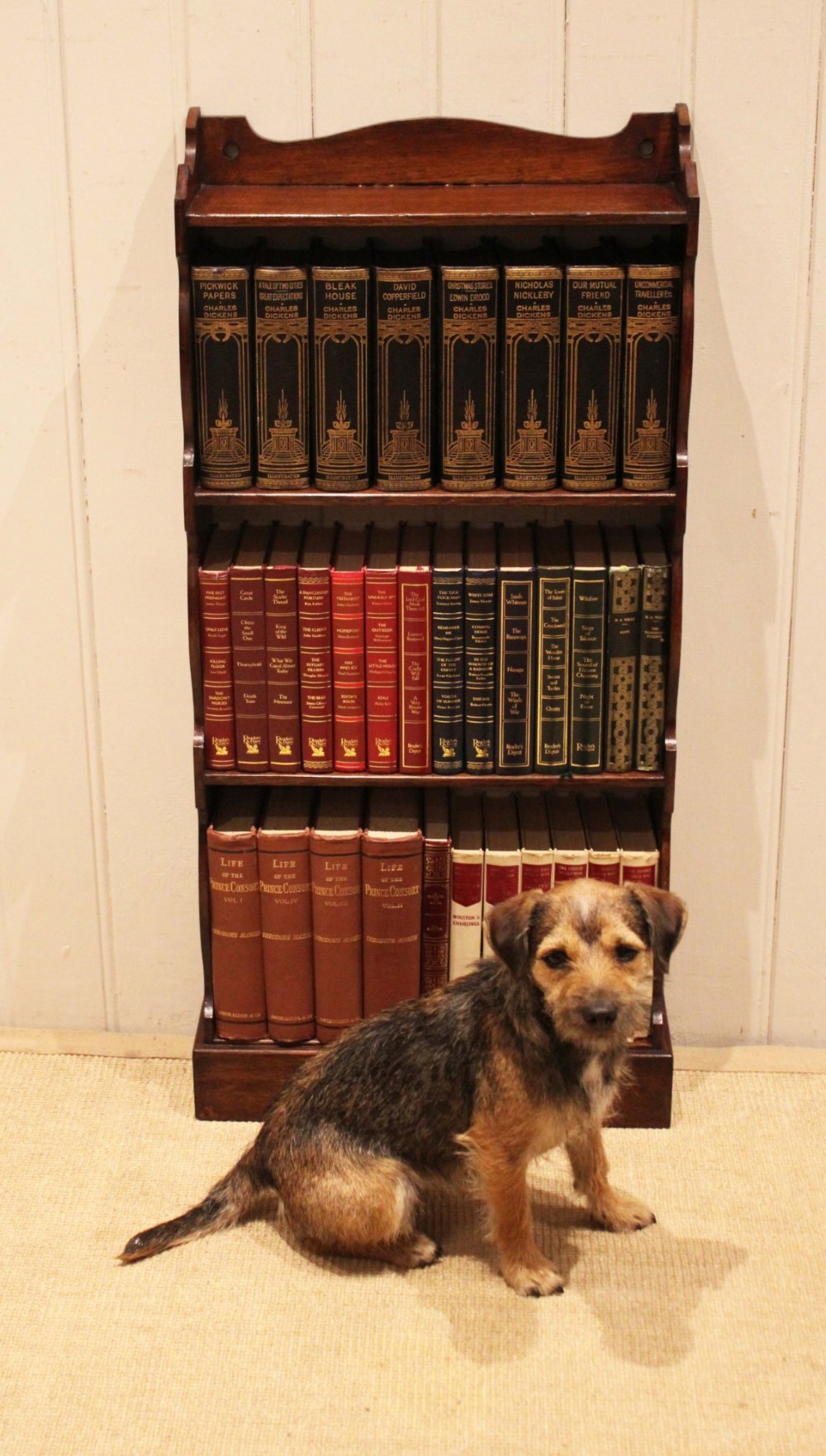 A small dark oak open bookcase featuring four tier shelves, shaped side panels, and a scrolled top gallery. View VII