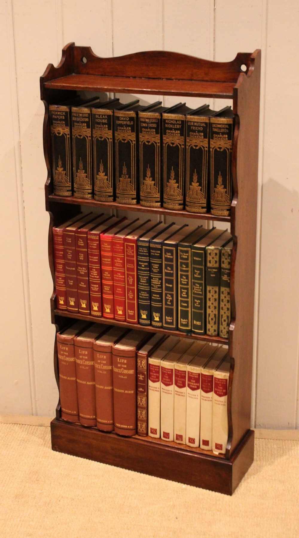 A small dark oak open bookcase featuring four tier shelves, shaped side panels, and a scrolled top gallery. View XI