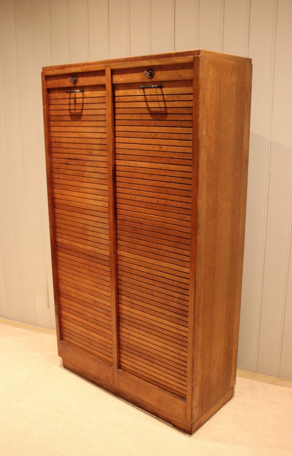 A tall French oak filing cabinet featuring twin vertical tambour slatted doors with metal handles and keyholes. View III