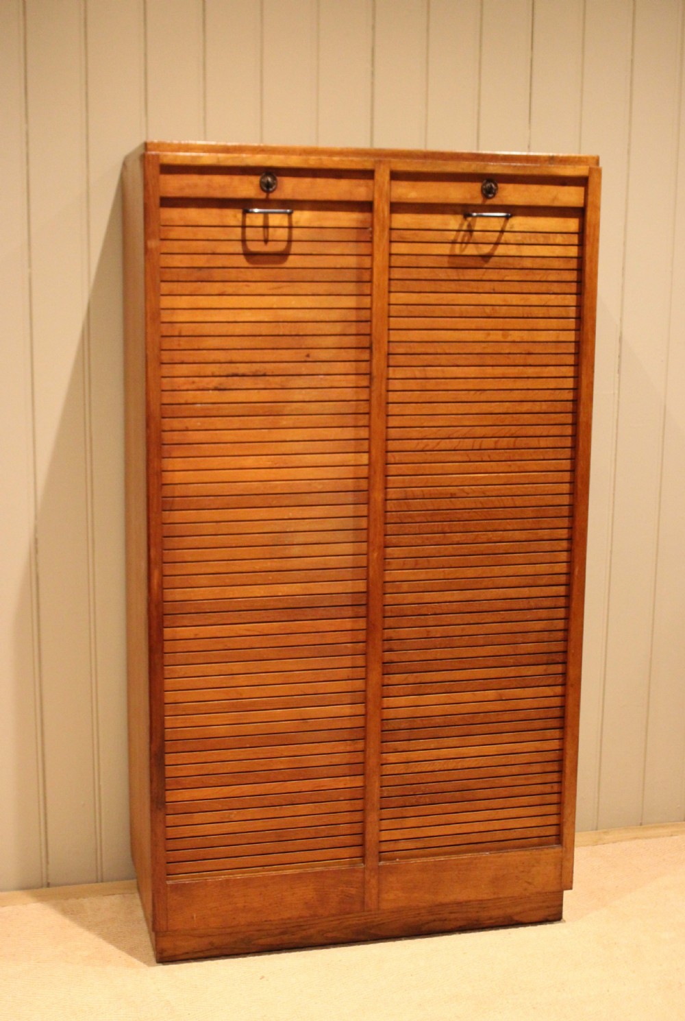 A tall French oak filing cabinet featuring twin vertical tambour slatted doors with metal handles and keyholes. View V