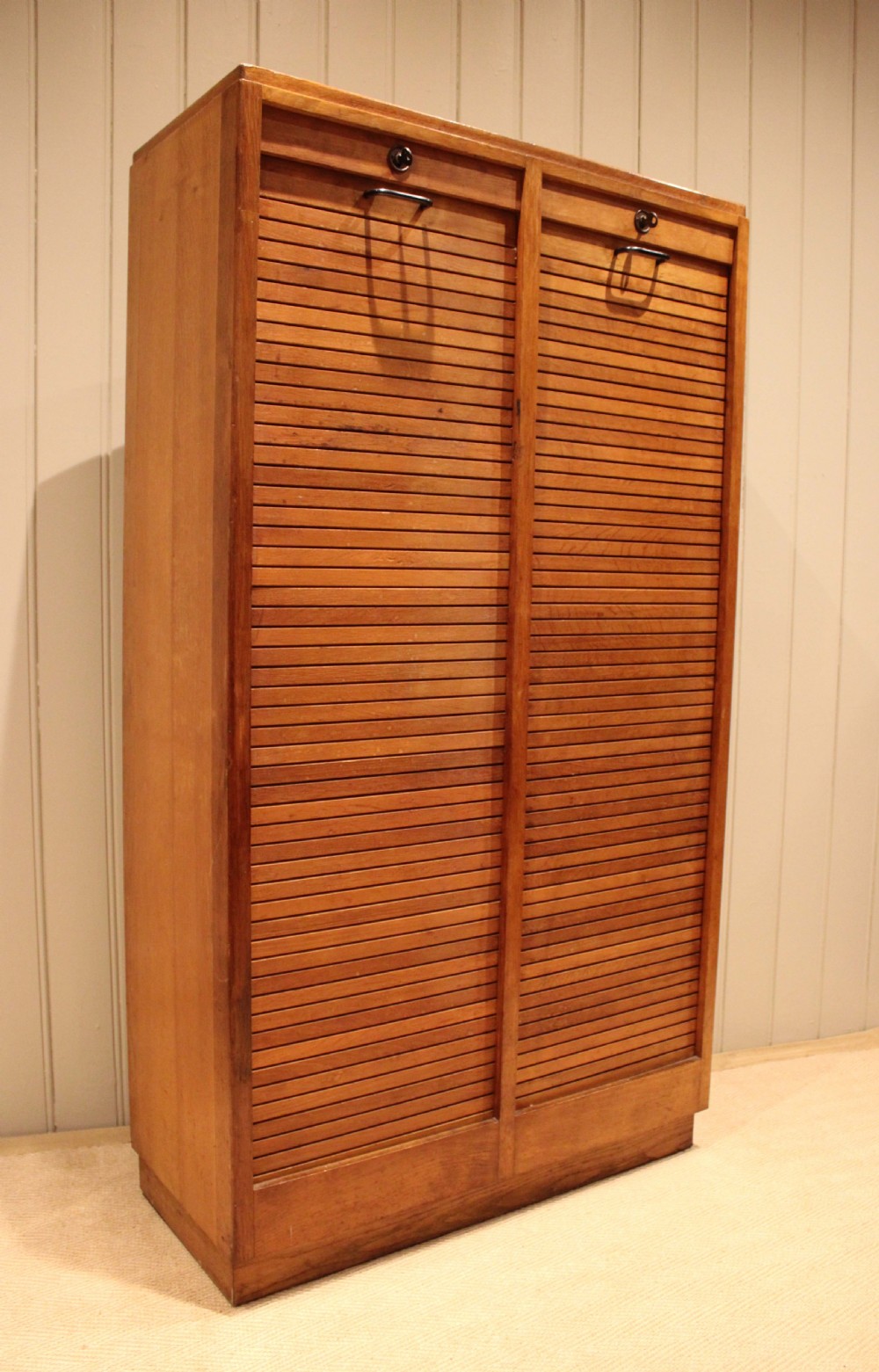 A tall French oak filing cabinet featuring twin vertical tambour slatted doors with metal handles and keyholes. View VII