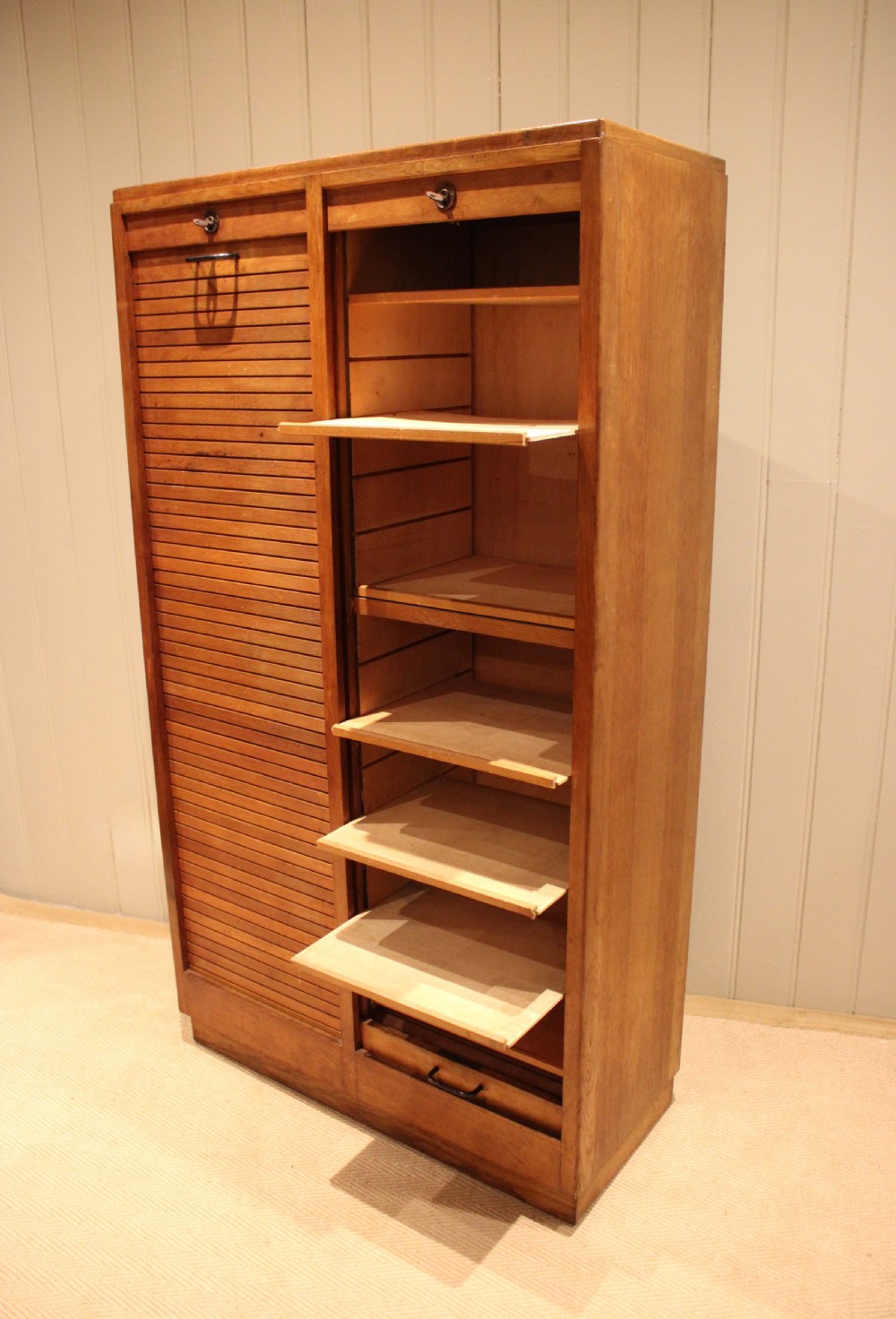 A tall French oak filing cabinet featuring twin vertical tambour slatted doors with metal handles and keyholes. View VIII