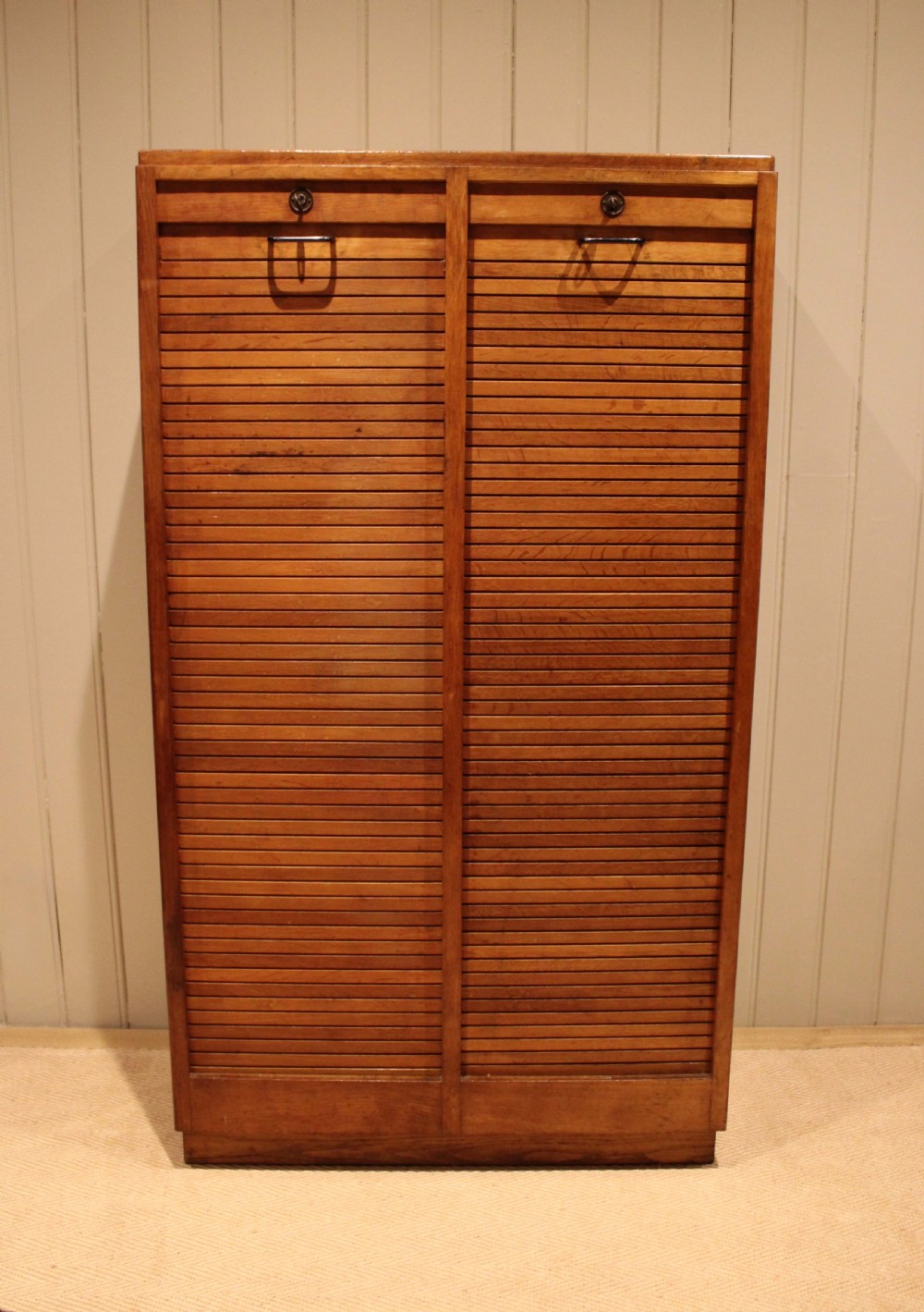 A tall French oak filing cabinet featuring twin vertical tambour slatted doors with metal handles and keyholes. View IX