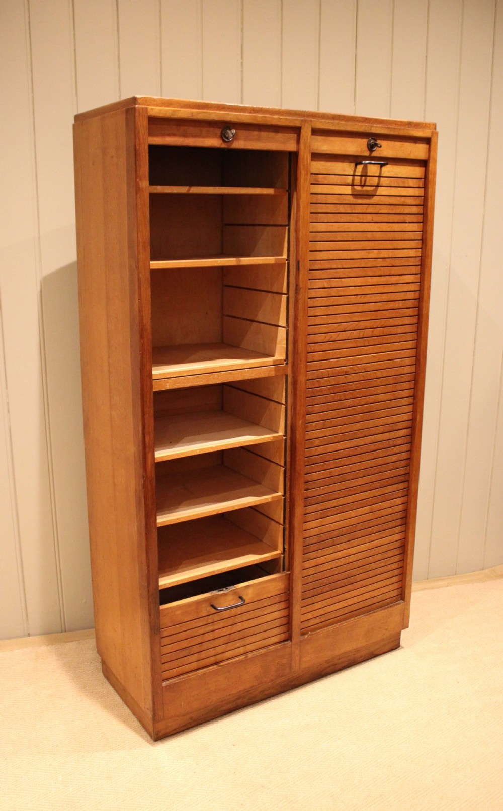 A tall French oak filing cabinet featuring twin vertical tambour slatted doors with metal handles and keyholes. View XI