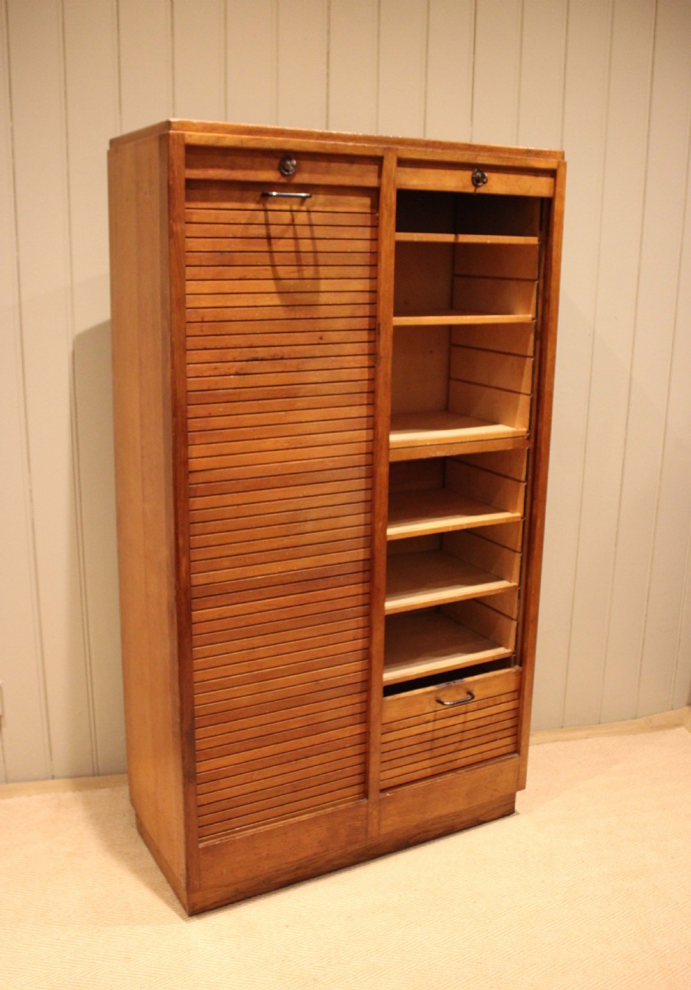 A tall French oak filing cabinet featuring twin vertical tambour slatted doors with metal handles and keyholes. View XII