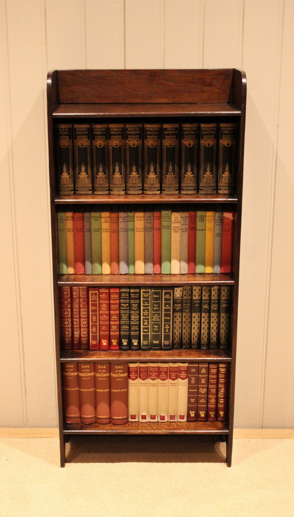 A tall dark oak open bookcase with four fixed shelves and shaped side profile cut-outs at the base. View III