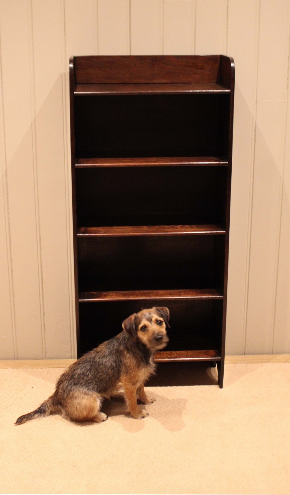 A tall dark oak open bookcase with four fixed shelves and shaped side profile cut-outs at the base. View IV