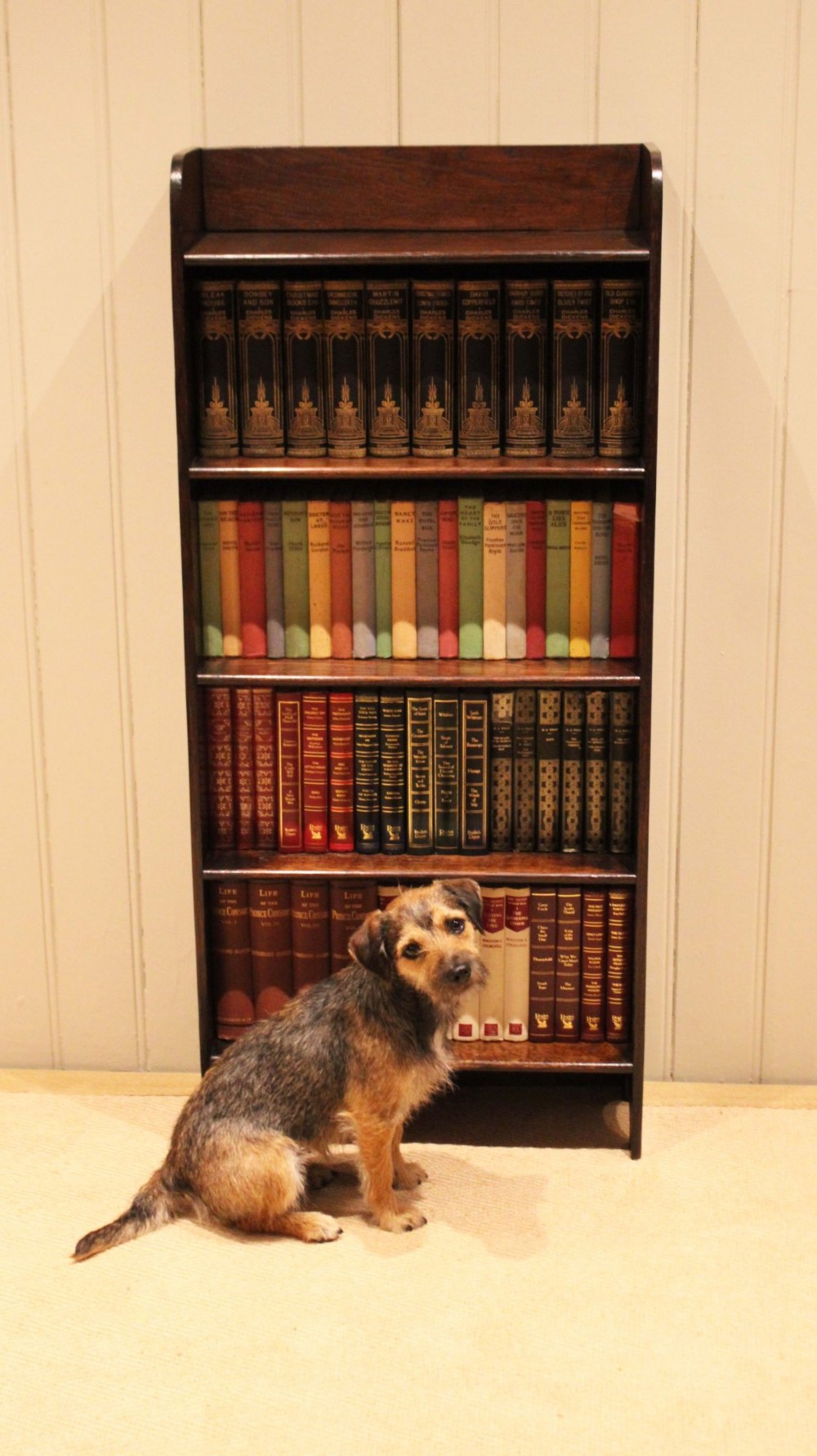 A tall dark oak open bookcase with four fixed shelves and shaped side profile cut-outs at the base. View XI