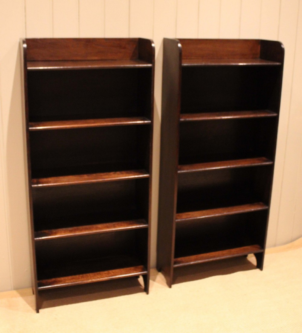 A tall dark oak open bookcase with four fixed shelves and shaped side profile cut-outs at the base. View XII