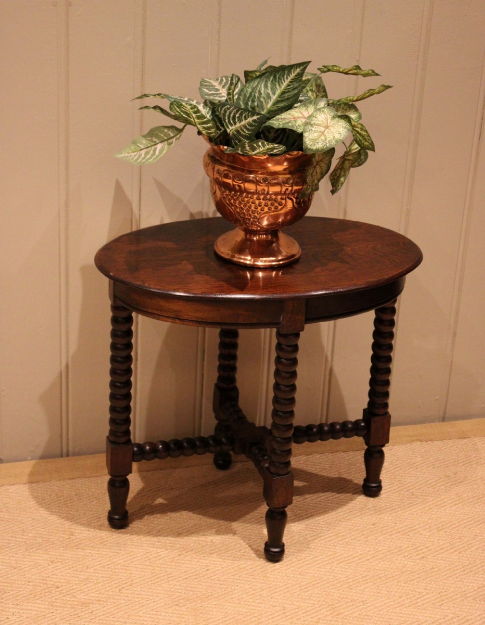 An antique dark oak side table featuring a smooth oval top supported by four bobbin-turned legs and matching low stretchers. View VIII