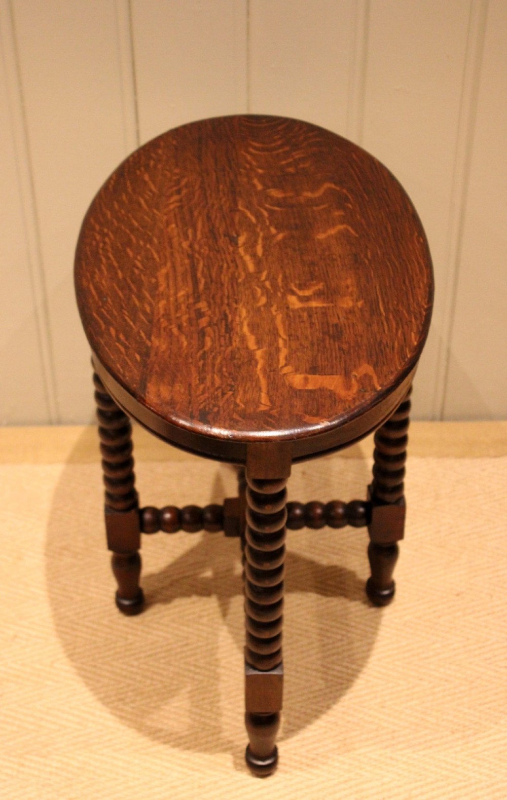 An antique dark oak side table featuring a smooth oval top supported by four bobbin-turned legs and matching low stretchers. View IX