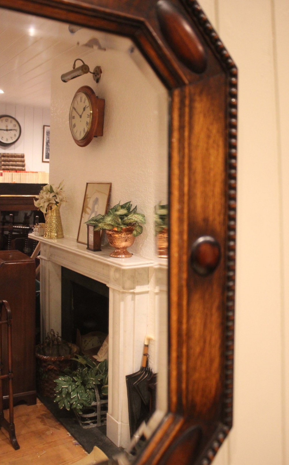 A large rectangular oak wall mirror with canted corners, beaded outer moulding, carved oval bosses, and a bevelled glass plate. View VII