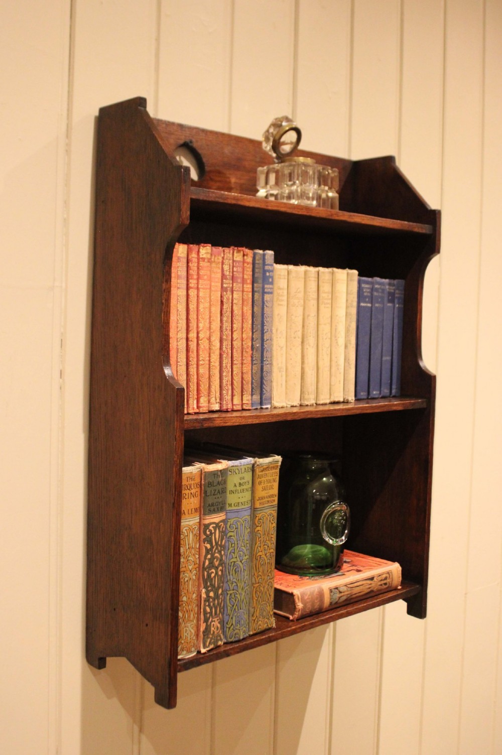 Dark oak Arts and Crafts three-tier wall shelving unit with two pierced heart cut-outs along the upper gallery rail. View XI