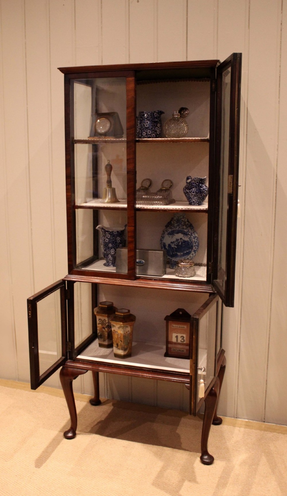 An Edwardian dark mahogany display cabinet with glazed doors and sides, resting on cabriole legs with pad feet. View V
