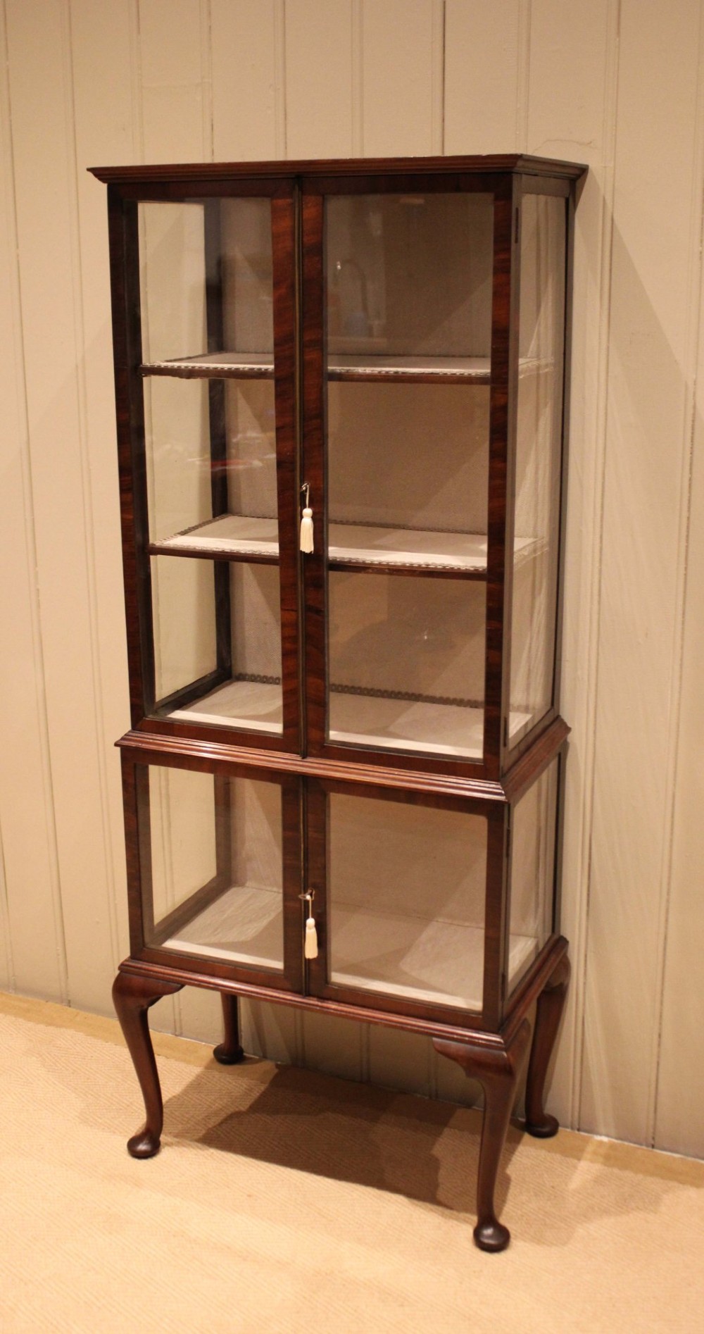 An Edwardian dark mahogany display cabinet with glazed doors and sides, resting on cabriole legs with pad feet. View VIII