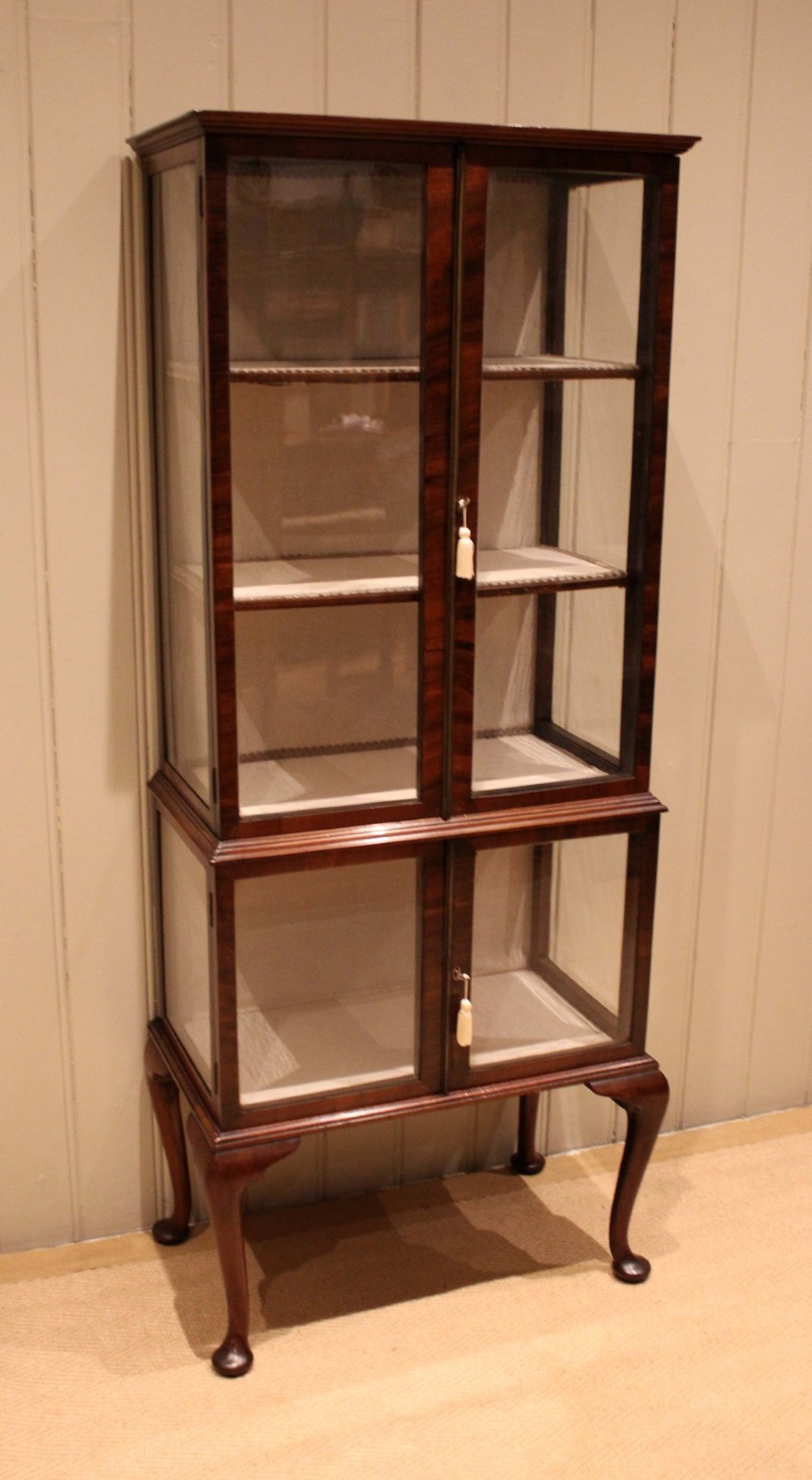 An Edwardian dark mahogany display cabinet with glazed doors and sides, resting on cabriole legs with pad feet. View X
