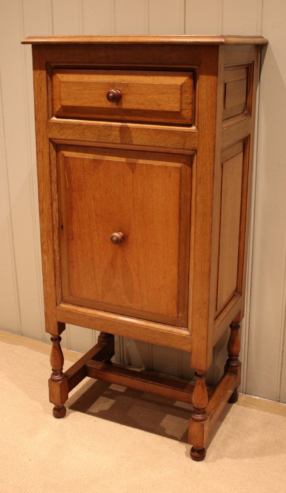 An Edwardian oak side cabinet featuring a single top drawer over a cupboard door with turned wooden knobs and turned legs. View III
