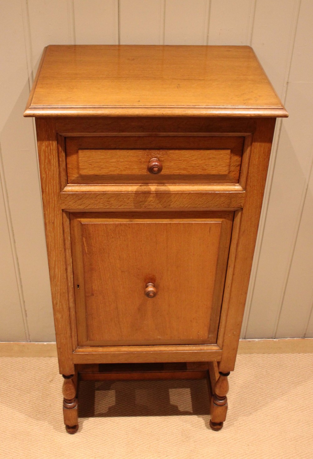 An Edwardian oak side cabinet featuring a single top drawer over a cupboard door with turned wooden knobs and turned legs. View IX