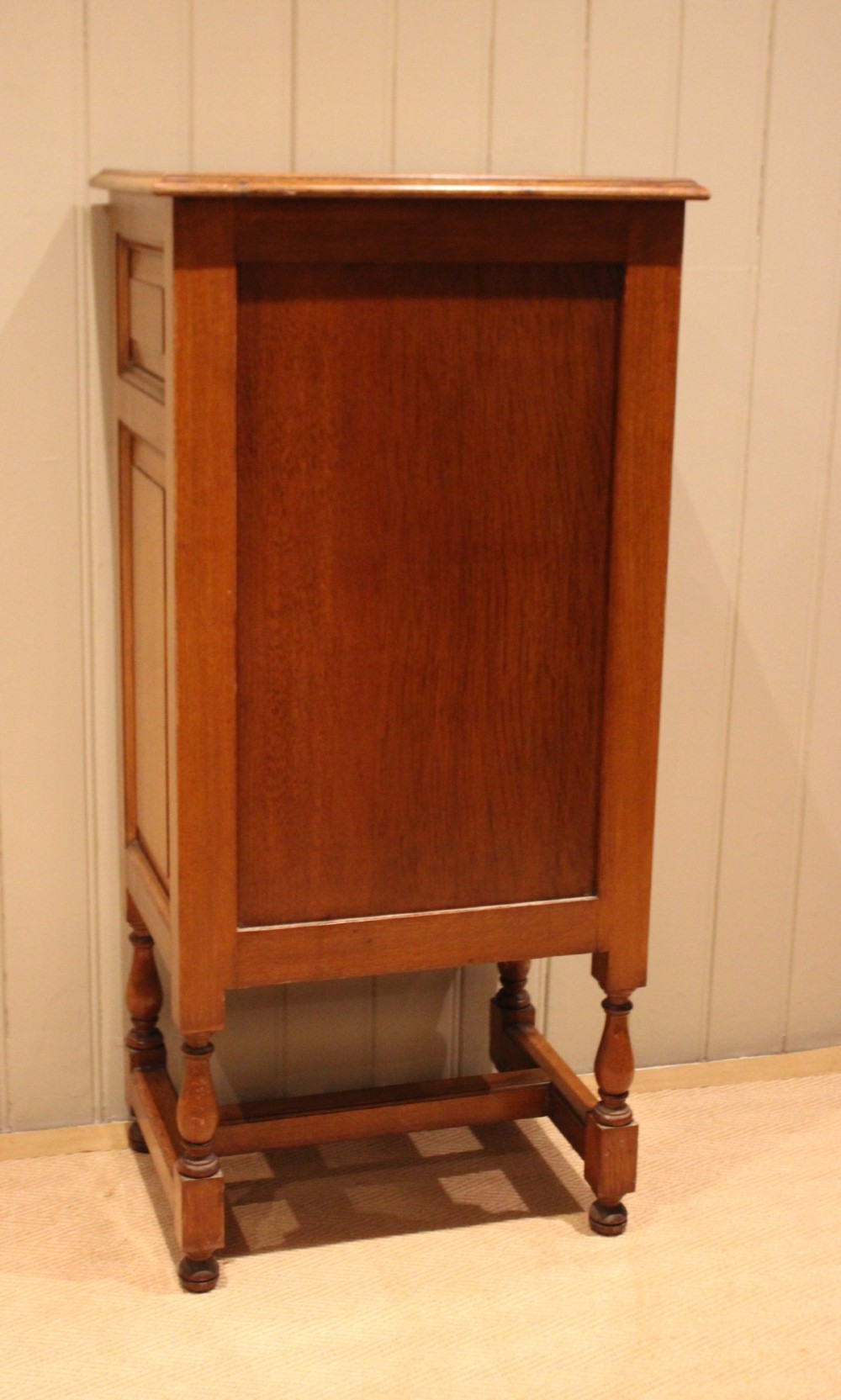 An Edwardian oak side cabinet featuring a single top drawer over a cupboard door with turned wooden knobs and turned legs. View XII