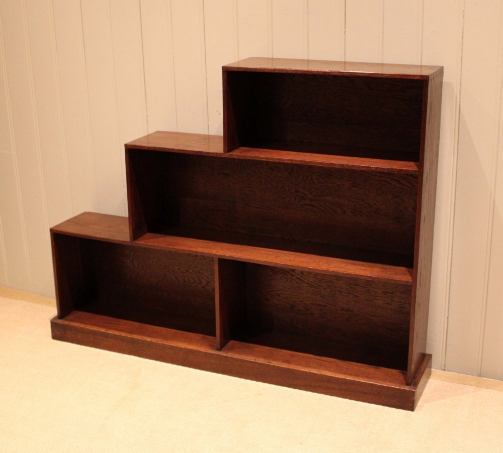 A stepped medium brown oak sectional bookcase with three open tiered shelves arranged in an asymmetrical stair-like configuration. View IV