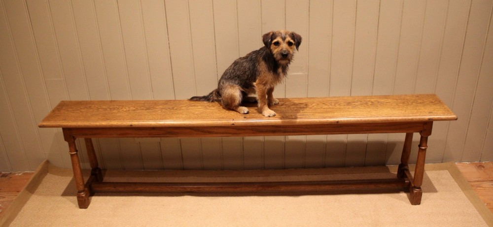A long rectangular solid oak bench featuring turned legs connected by a low stretcher rail. View IV