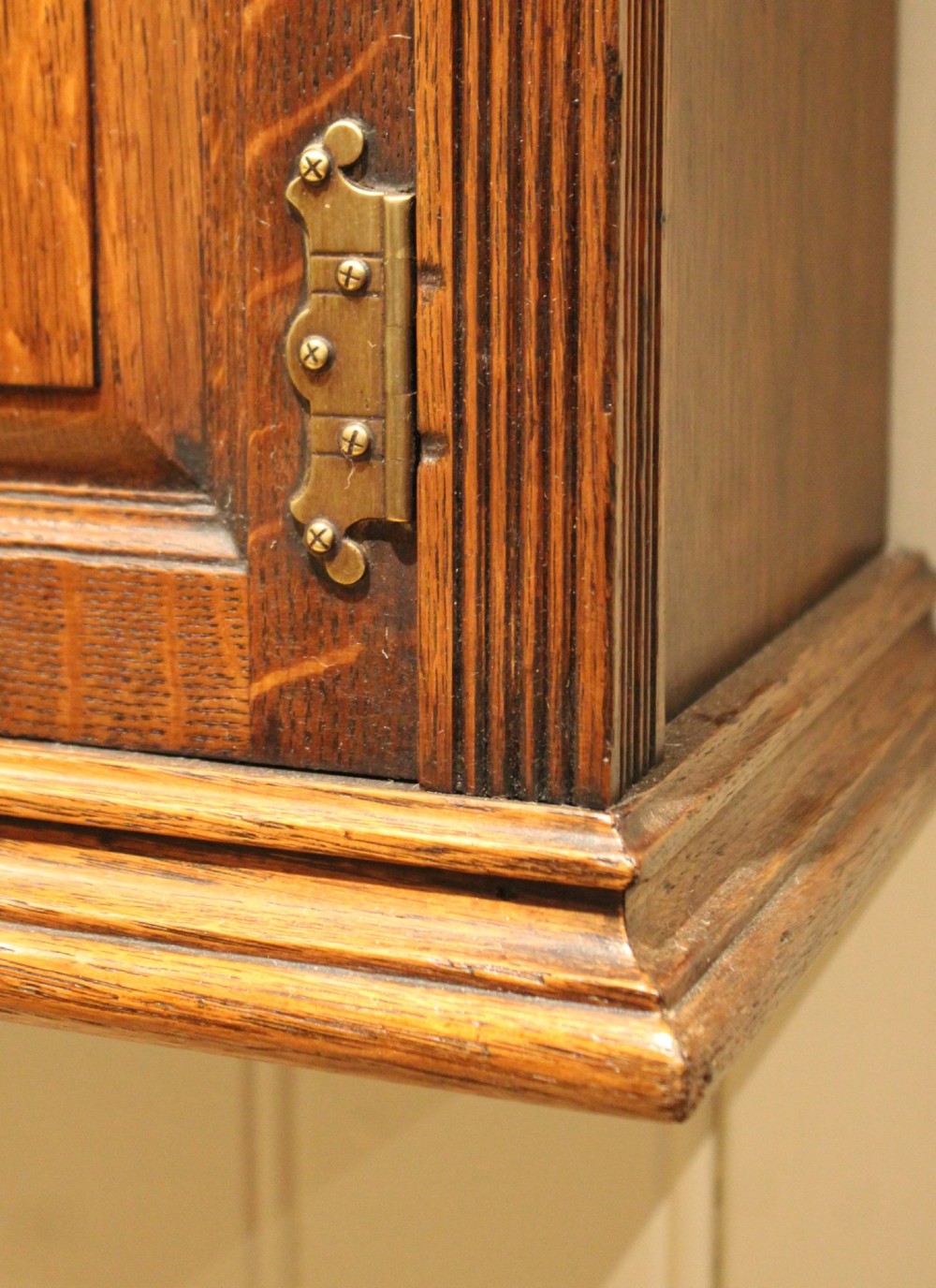 A late nineteenth-century solid oak wall cabinet featuring panelled double doors with brass hinges and handles. View X
