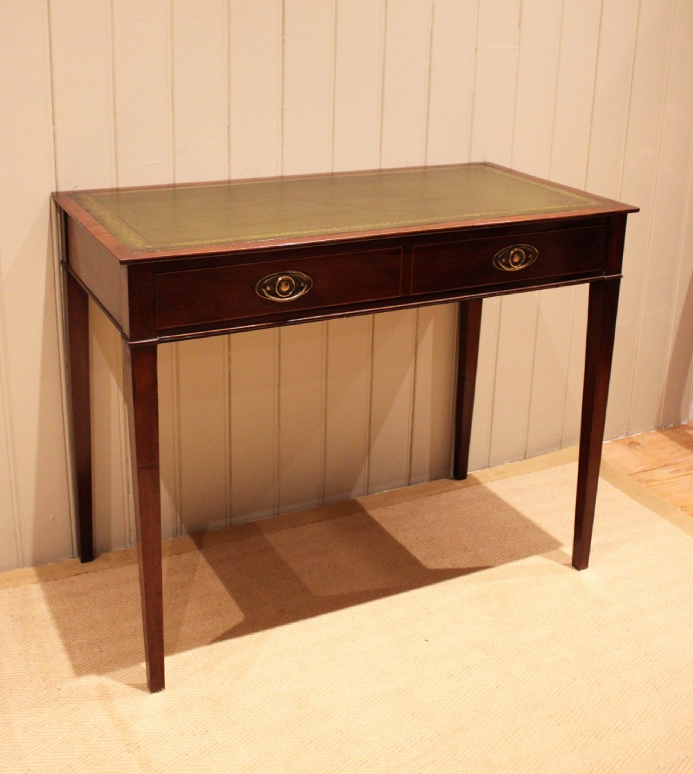 An early 19th-century mahogany writing desk featuring a green leather inset top, two frieze drawers with brass oval handles, and square tapered legs.