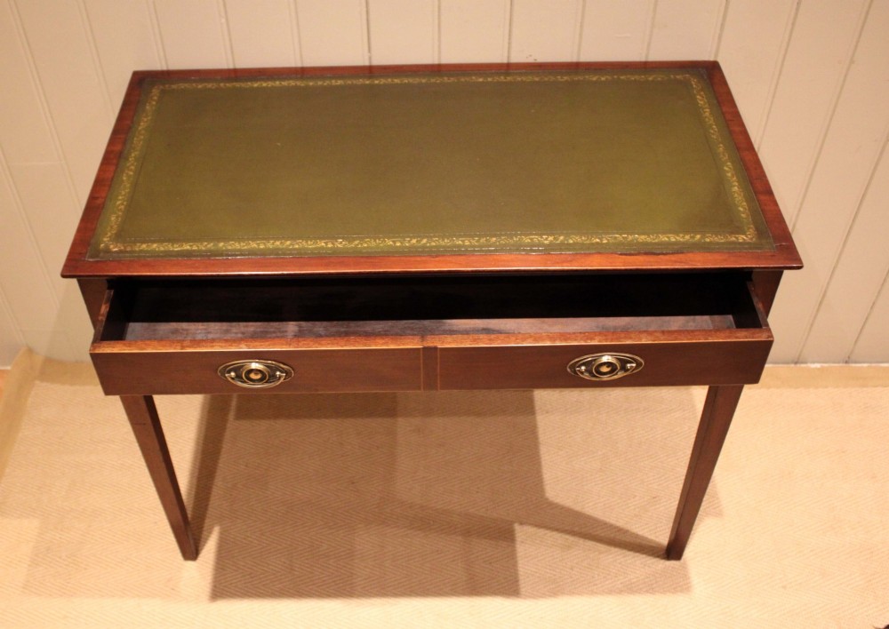 An early 19th-century mahogany writing desk featuring a green leather inset top, two frieze drawers with brass oval handles, and square tapered legs. View III