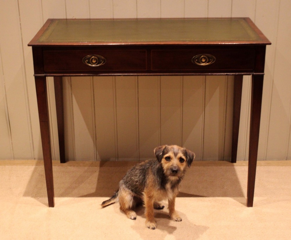 An early 19th-century mahogany writing desk featuring a green leather inset top, two frieze drawers with brass oval handles, and square tapered legs. View VIII