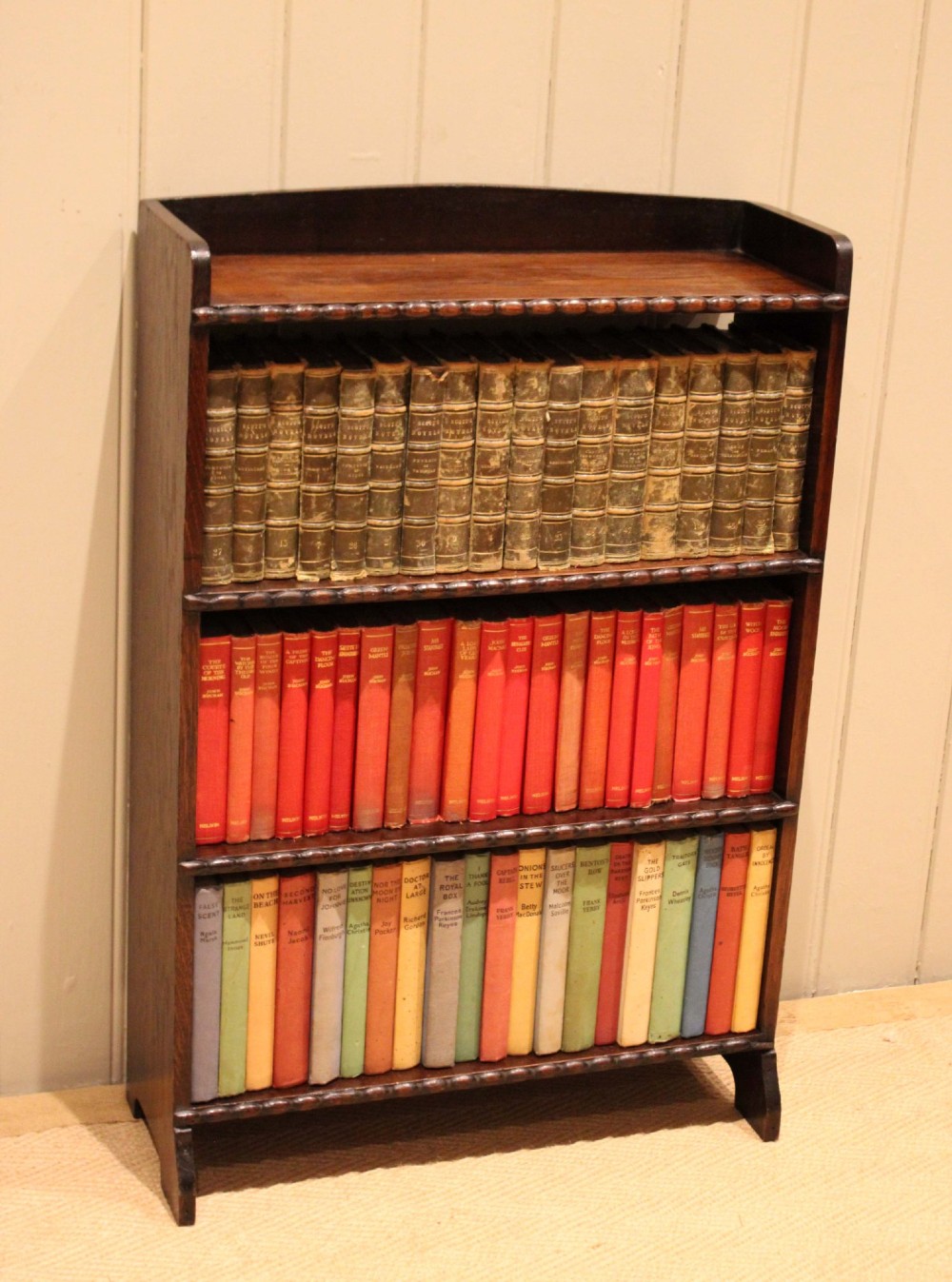A small dark oak open bookcase with three fixed shelves and beaded edge moulding along each front shelf border. View III