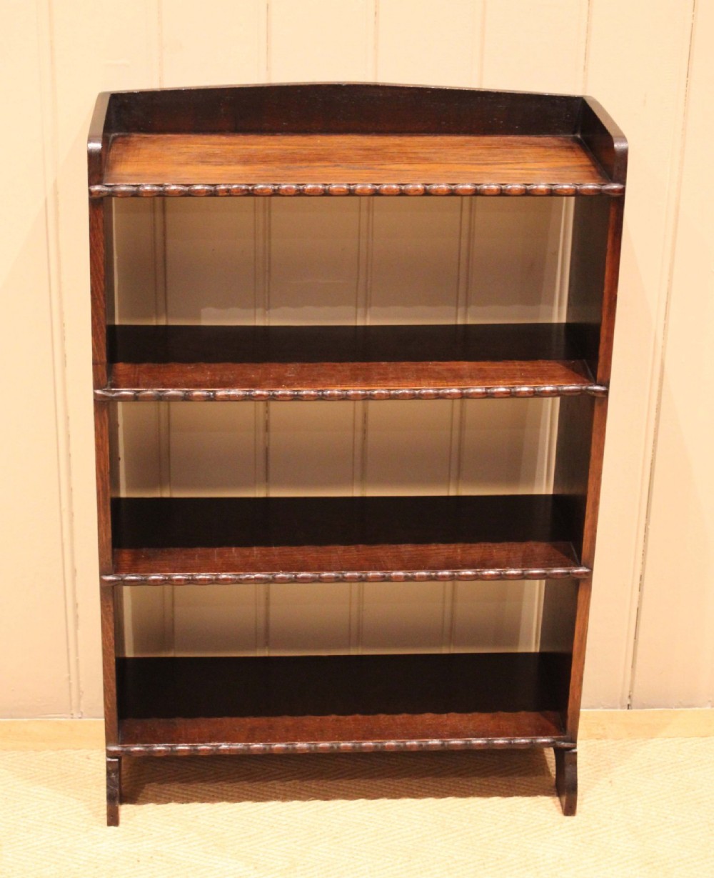 A small dark oak open bookcase with three fixed shelves and beaded edge moulding along each front shelf border. View IV