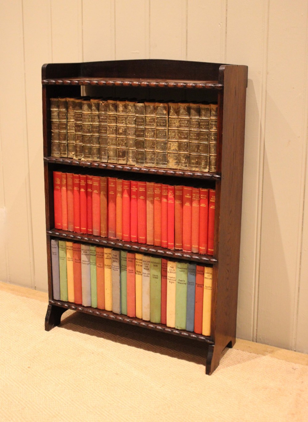A small dark oak open bookcase with three fixed shelves and beaded edge moulding along each front shelf border. View V