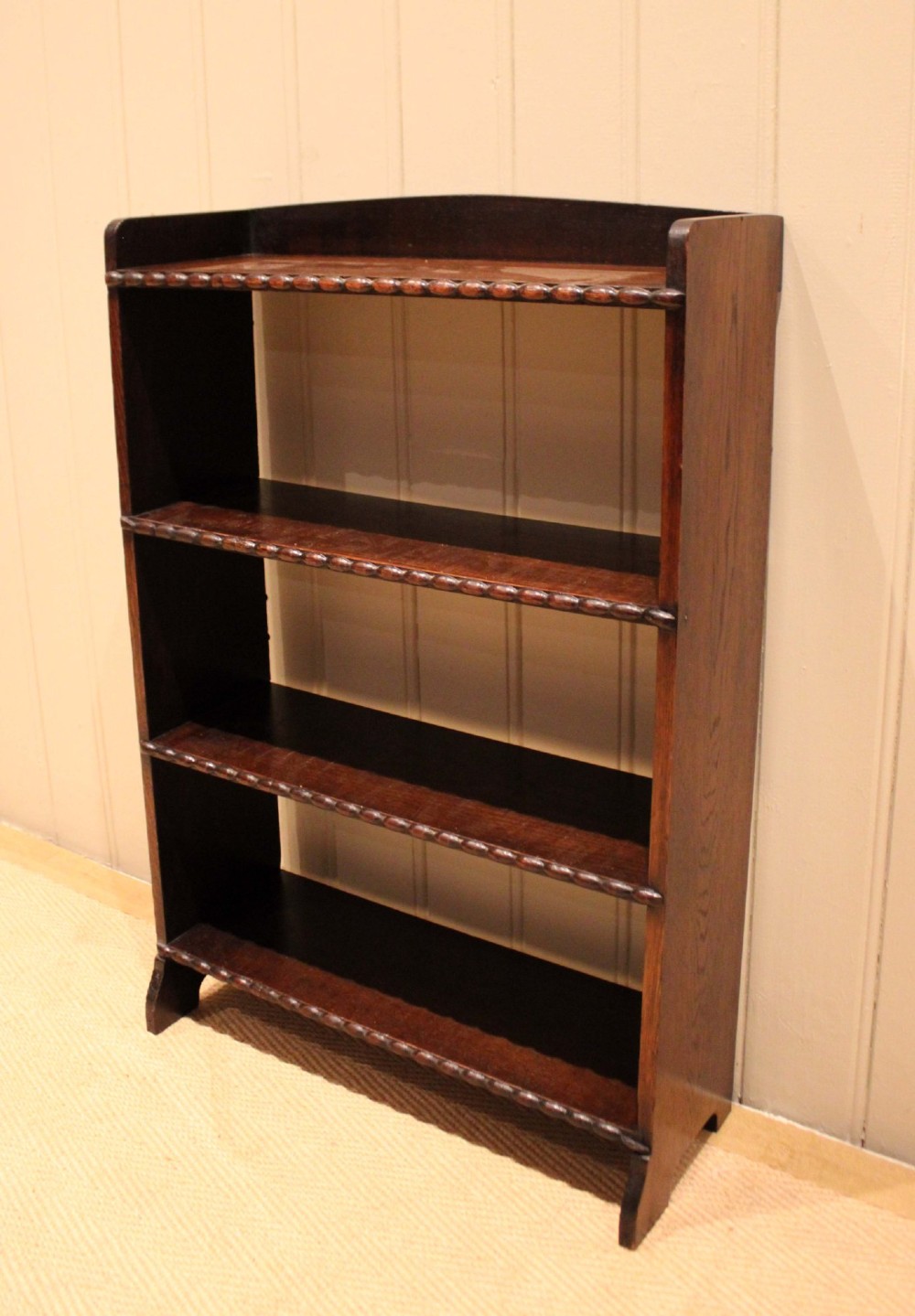 A small dark oak open bookcase with three fixed shelves and beaded edge moulding along each front shelf border. View VI