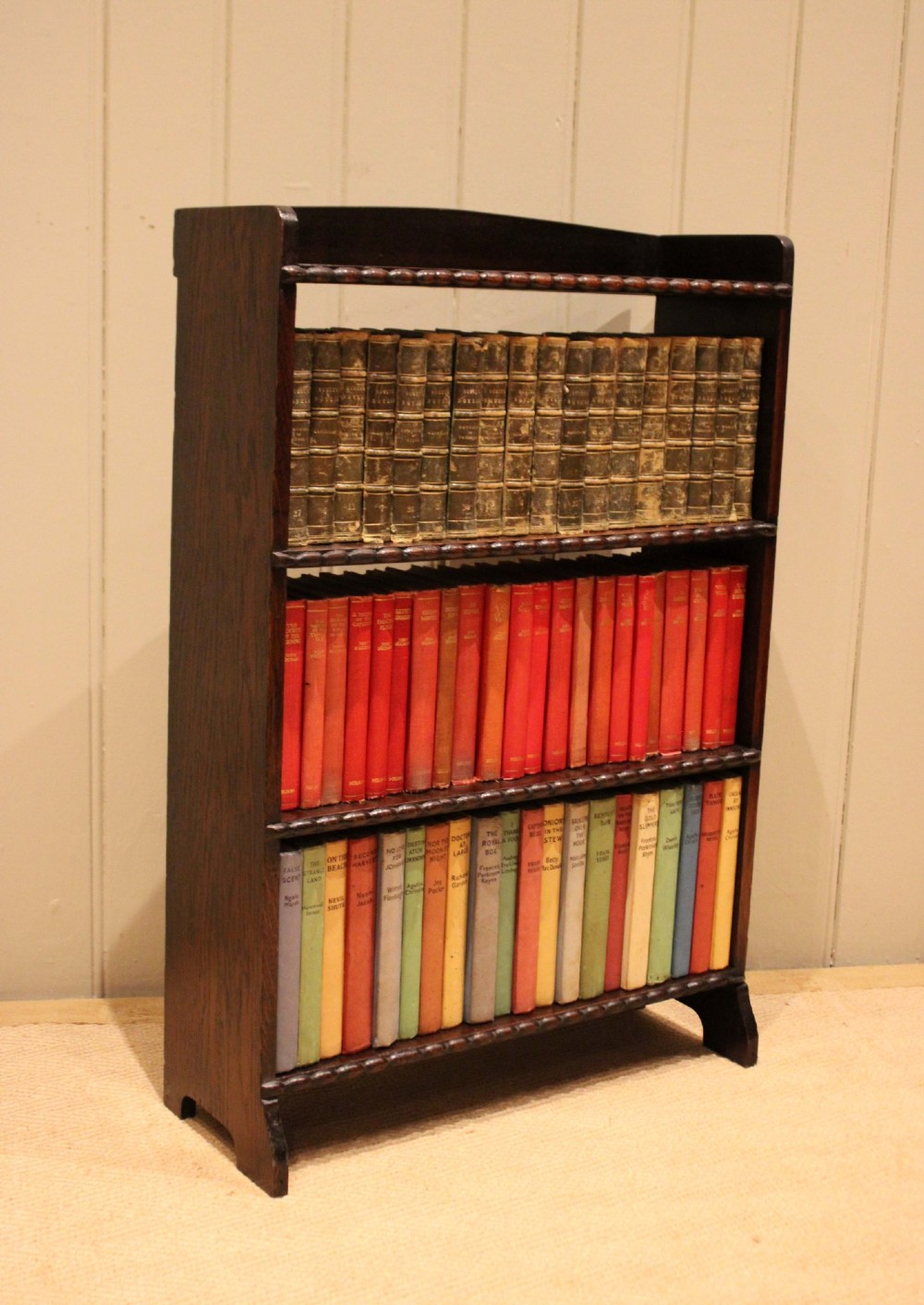 A small dark oak open bookcase with three fixed shelves and beaded edge moulding along each front shelf border. View VII