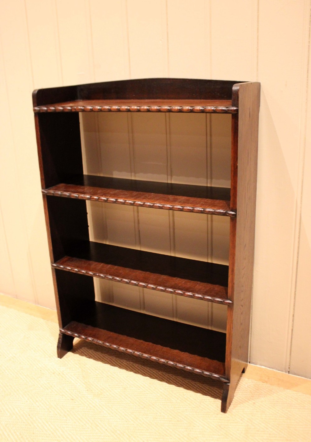 A small dark oak open bookcase with three fixed shelves and beaded edge moulding along each front shelf border. View VIII