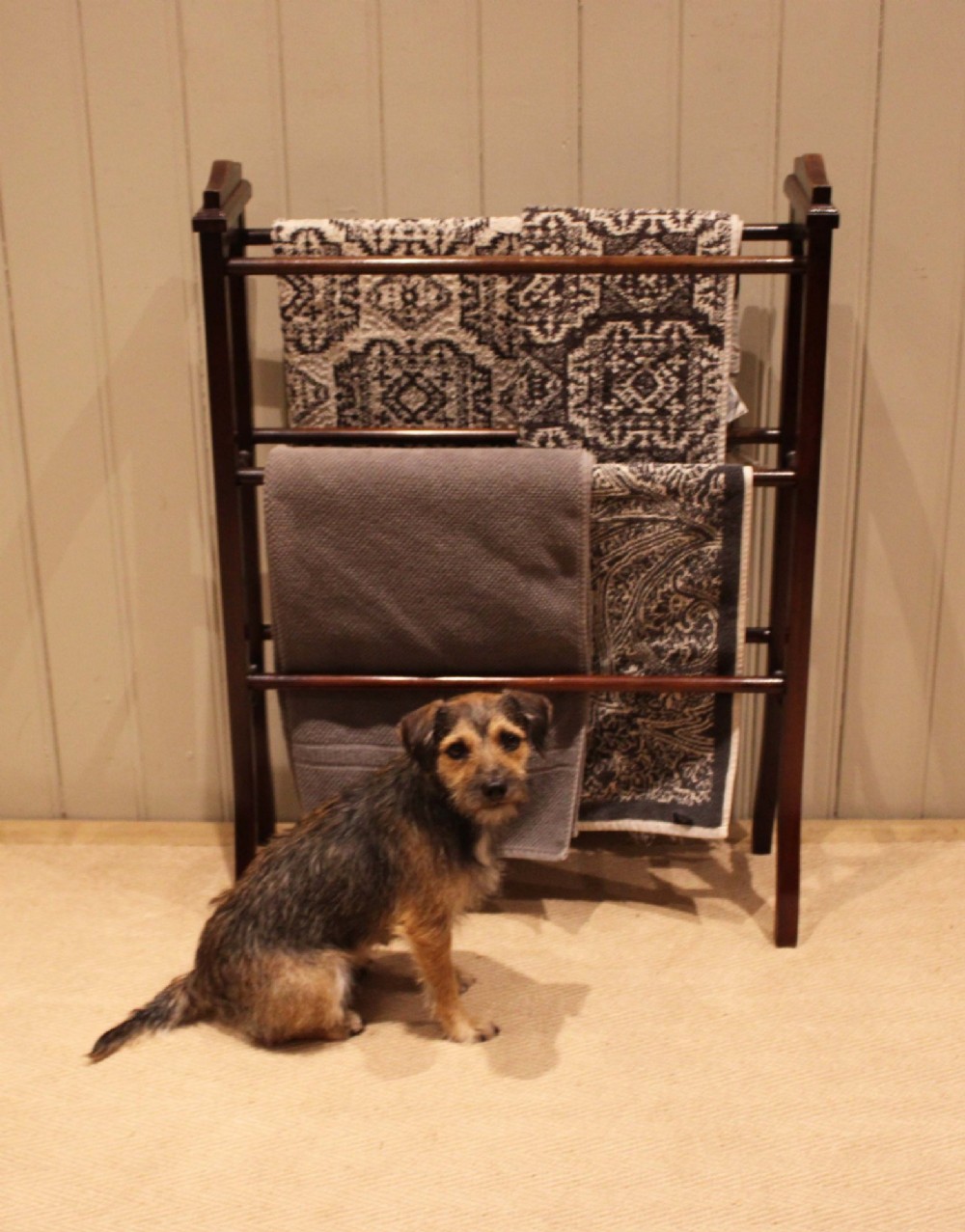 An Edwardian freestanding dark mahogany towel rail featuring six turned horizontal bars and splayed legs. View XI