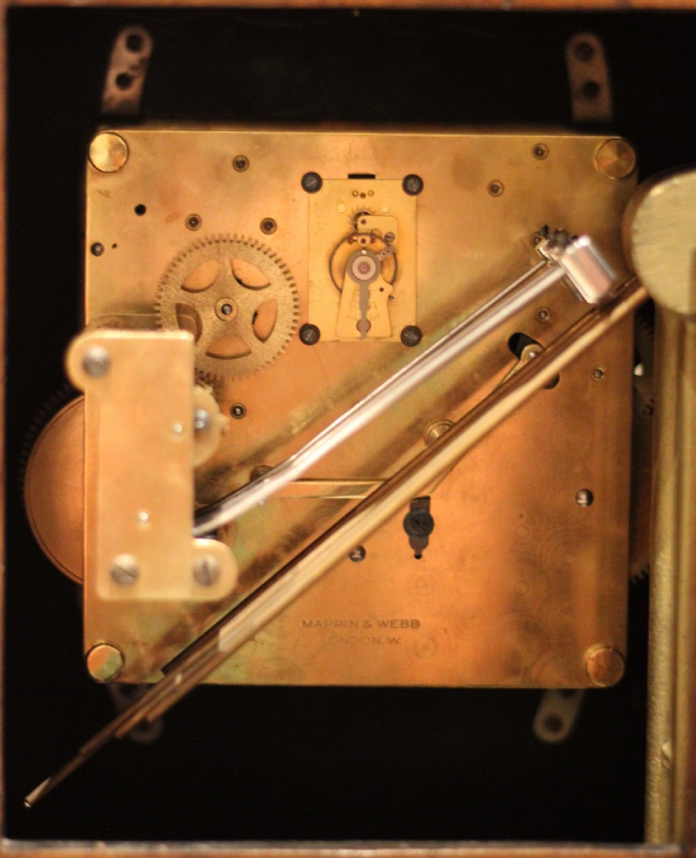 A burr walnut bracket clock featuring a caddy top with a brass carry handle, an ornate brass dial with a silvered chapter ring, and brass bracket feet. View X
