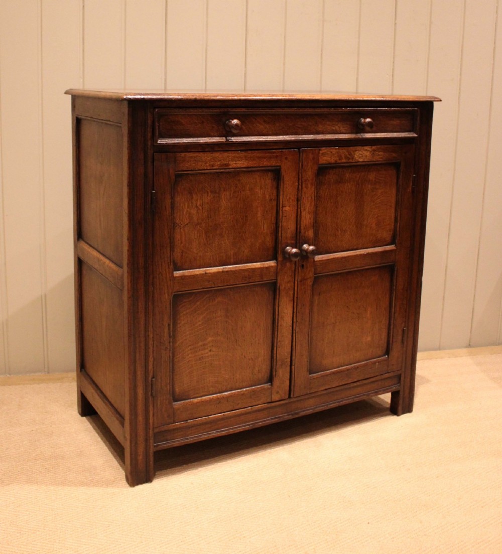 A late nineteenth-century solid oak side cabinet featuring a single top drawer above two panelled cupboard doors with turned timber handles. View VI