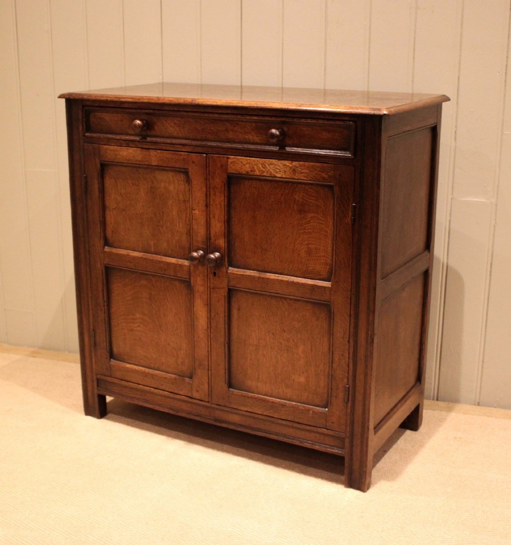 A late nineteenth-century solid oak side cabinet featuring a single top drawer above two panelled cupboard doors with turned timber handles. View VII
