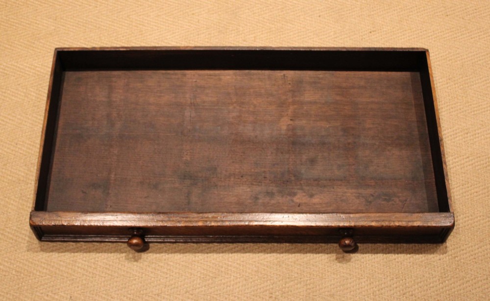A late nineteenth-century solid oak side cabinet featuring a single top drawer above two panelled cupboard doors with turned timber handles. View X