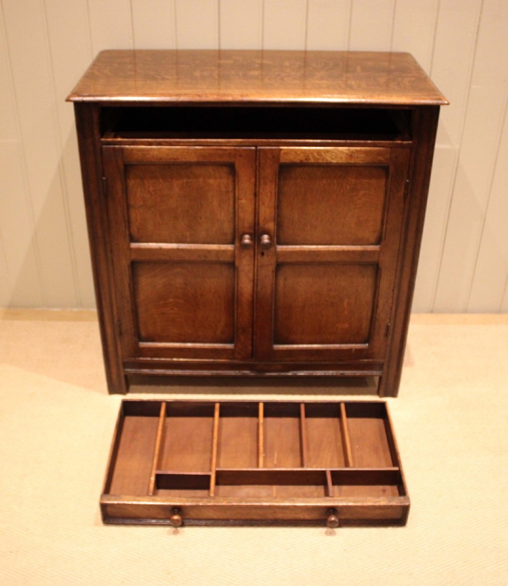 A late nineteenth-century solid oak side cabinet featuring a single top drawer above two panelled cupboard doors with turned timber handles. View XI